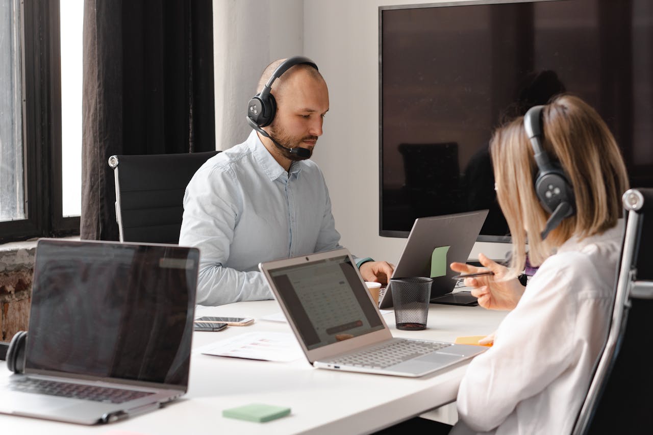 The Art of Drawing Readers In: Your attractive post title goes here Customer support agents working together with laptops and headsets in an office setting.