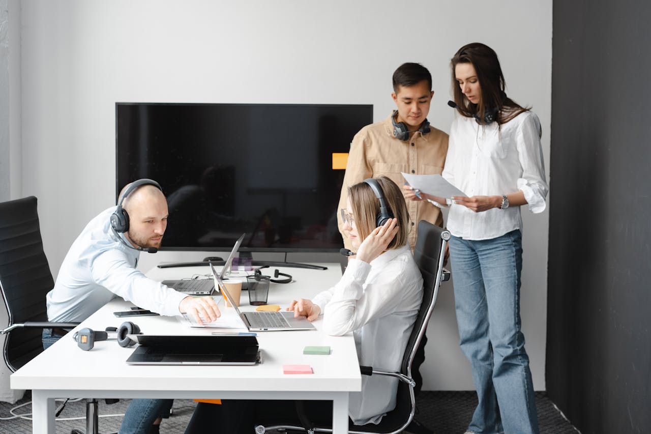 Mastering the First Impression: Your intriguing post title goes here Group of diverse colleagues working together in a modern office environment with headsets and laptops.