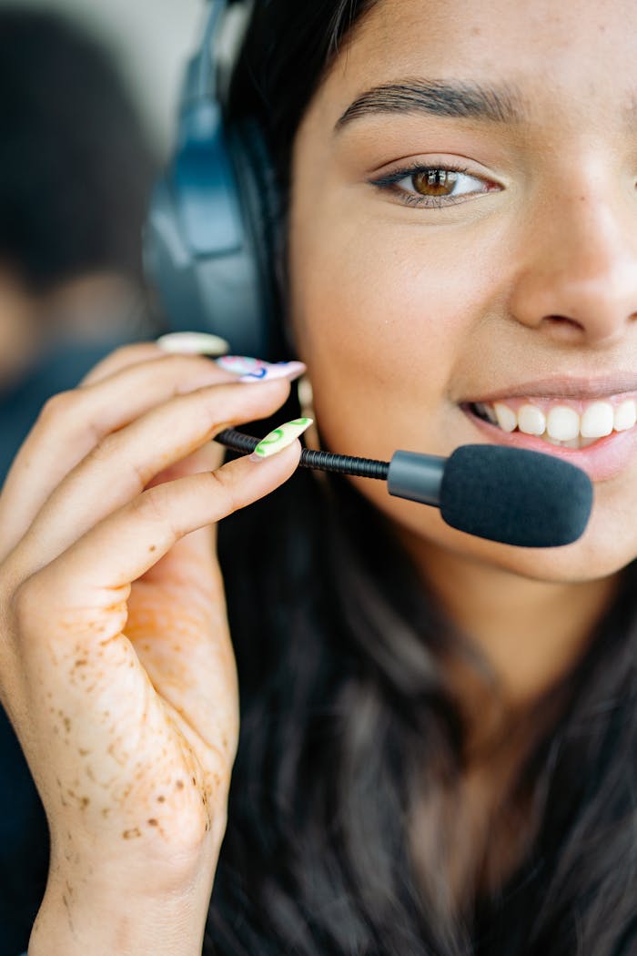 Services Close-up of a cheerful woman with headphones, engaged in a customer service role.